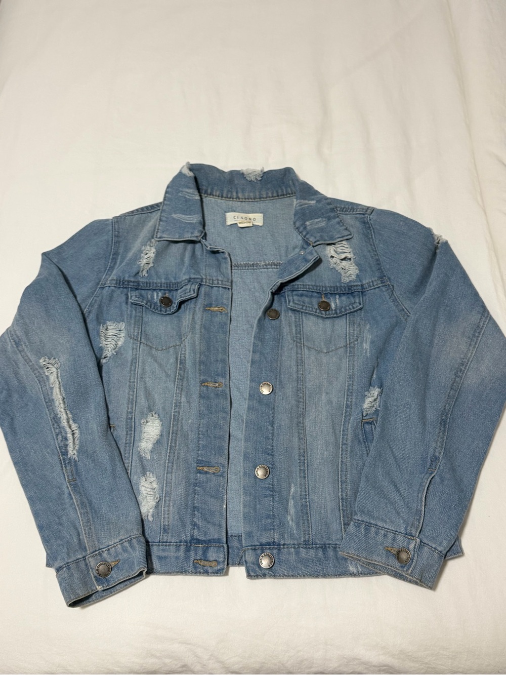Light blue denim jacket with distressed details